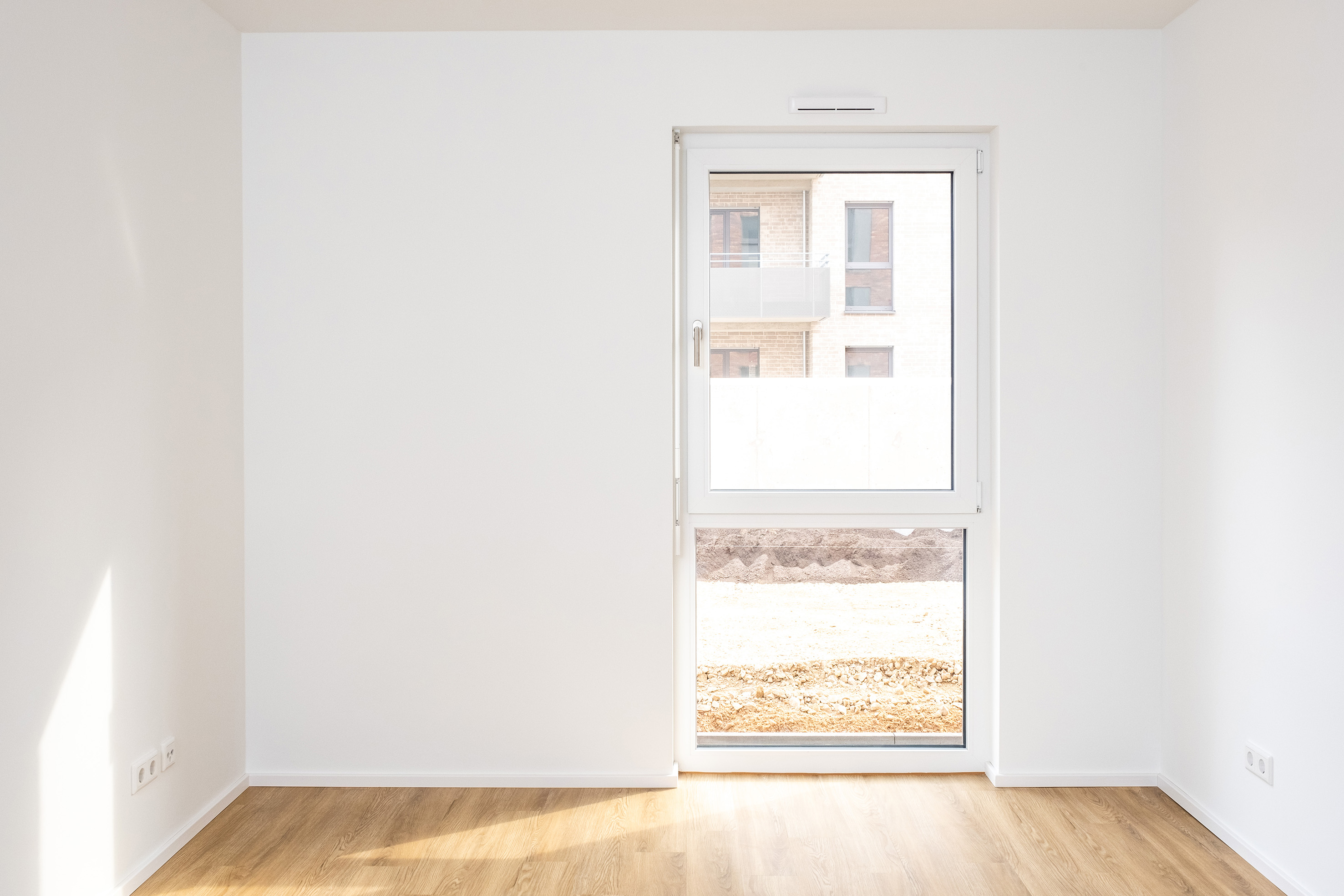 Neubau: ein schmales Zimmer mit einem bodentiefen Fenster
